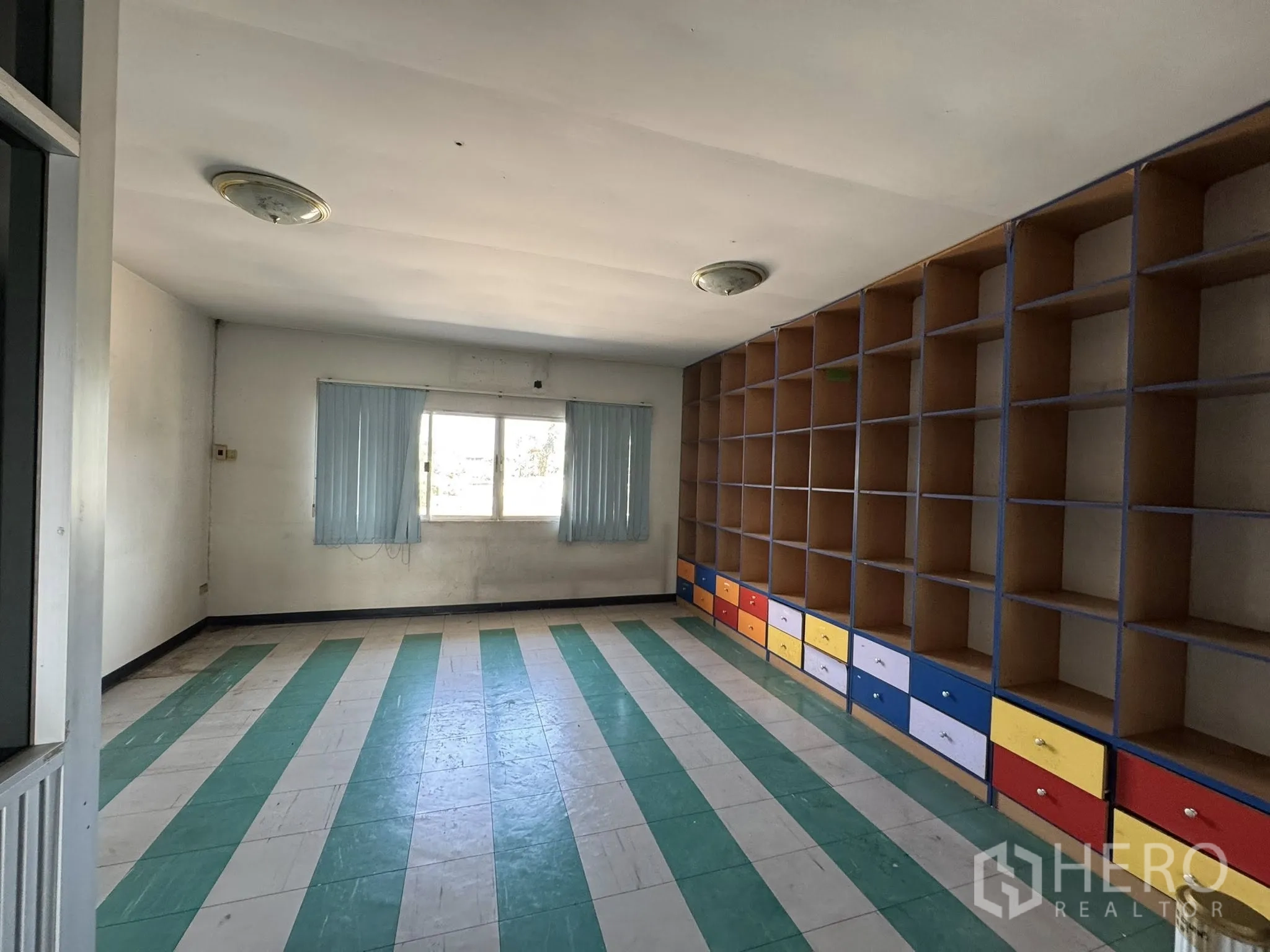 货栈 for rent in Mueang Samut Sakhon, Samut Sakhon - 办公室带整面储物格和彩色抽屉，绿白条纹地板。