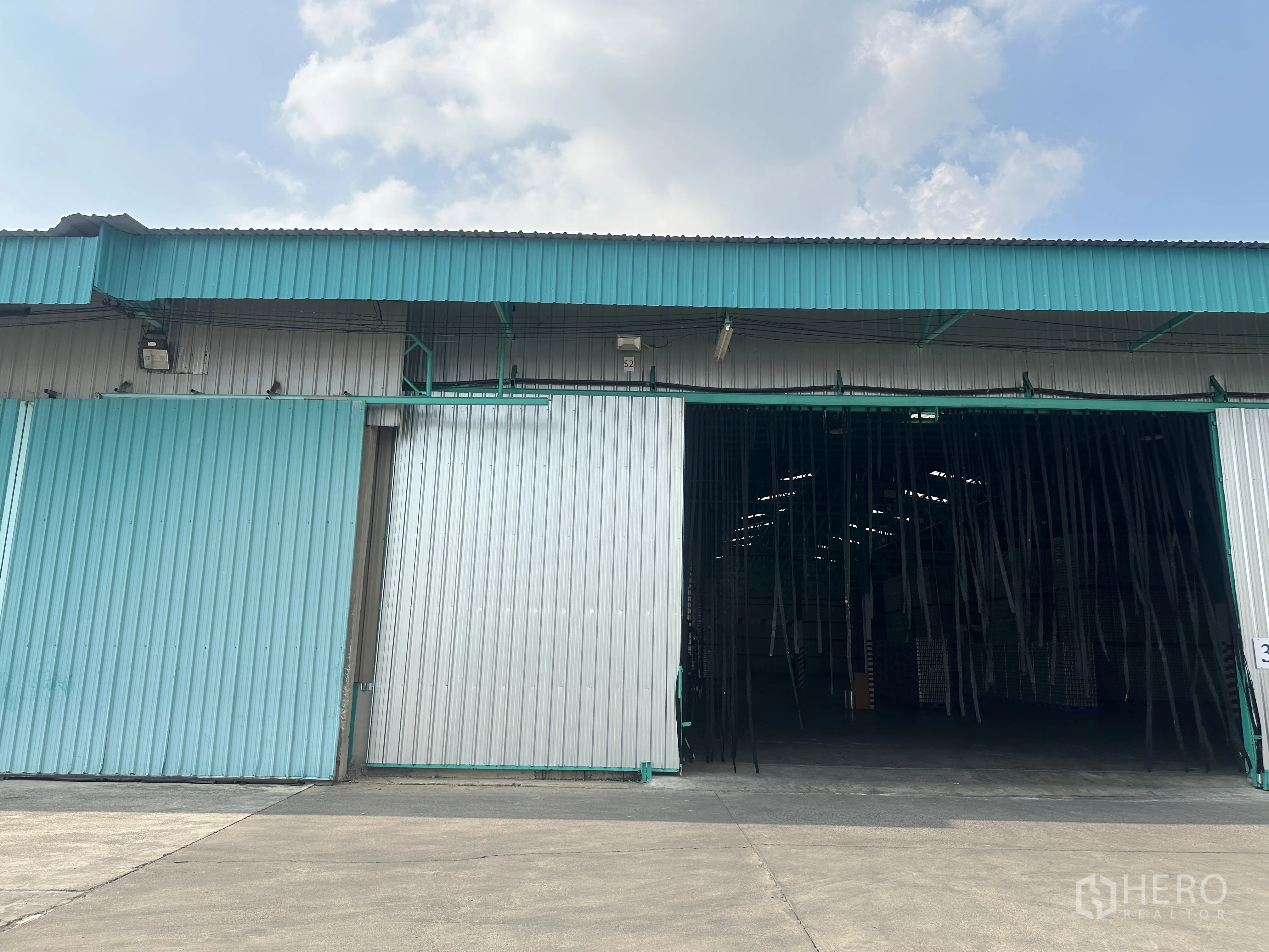 货栈 出租在Mueang Pathum Thani, Pathum Thani - 仓库外立面，金属围护与大型推拉门，前方宽阔车道，位于Bang Khayaeng的园区内。