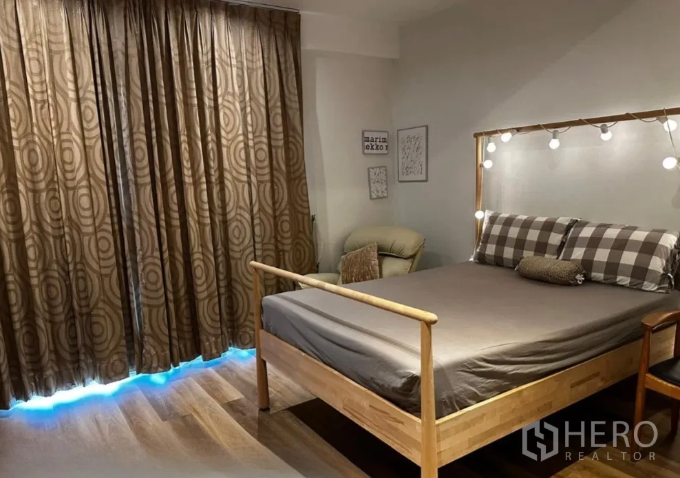 Townhouse for rent in Sathon, Bangkok - Bedroom with double bed, accent lights, armchair, and floor-length curtains.