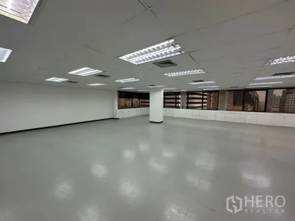 สำนักงาน ให้เช่าในWatthana, Bangkok - พื้นที่สำนักงานเปิดโล่ง พร้อมไฟฟลูออเรสเซนต์ ฝ้าเพดานสีขาว ตู้บิวท์อินใต้หน้าต่างกว้างและวิวเมือง.