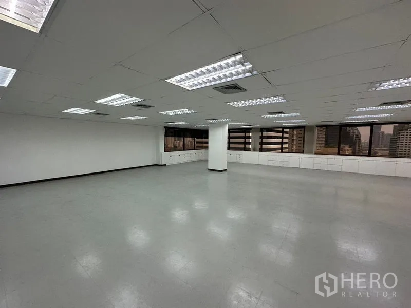 สำนักงาน ให้เช่าในWatthana, Bangkok - พื้นที่สำนักงานเปิดโล่ง พร้อมไฟฟลูออเรสเซนต์ ฝ้าเพดานสีขาว ตู้บิวท์อินใต้หน้าต่างกว้างและวิวเมือง.