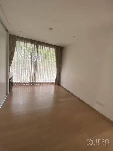 คอนโด ให้เช่าในPathum Wan, Bangkok - ห้องนอนอบอุ่น หน้าต่างบานใหญ่พร้อมผ้าม่าน พื้นไม้ และวิวเรือนยอดไม้