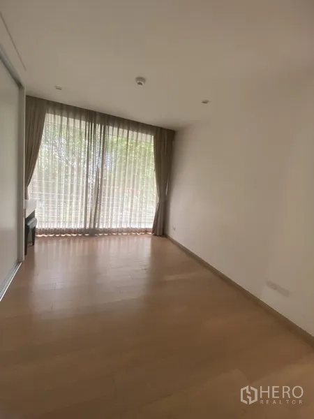 คอนโด ให้เช่าในPathum Wan, Bangkok - ห้องนอนอบอุ่น หน้าต่างบานใหญ่พร้อมผ้าม่าน พื้นไม้ และวิวเรือนยอดไม้