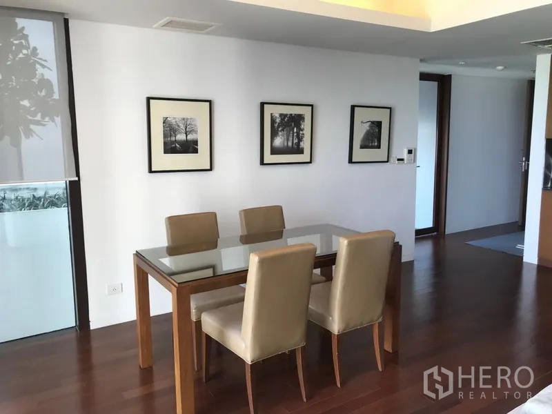 公寓 出租在Pathum Wan, Bangkok - 明亮餐区，玻璃餐桌、米色餐椅与墙面装饰画