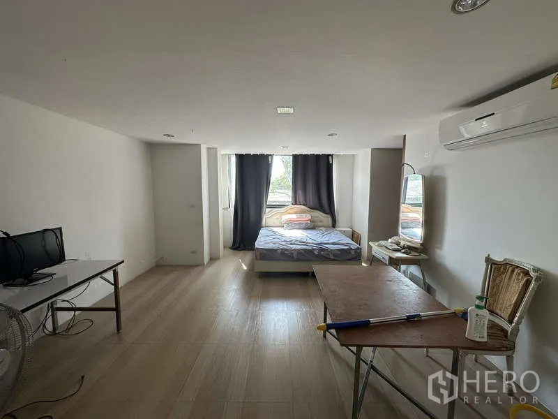 Home Office for sale in Lam Luk Ka, Pathum Thani - Simple bedroom with bed by the window, air conditioner and wood-look flooring