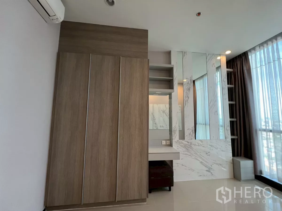 Condominium for rent in Phra Khanong, Bangkok - Wardrobe and shelving detail with mirrors beside large window in bedroom.