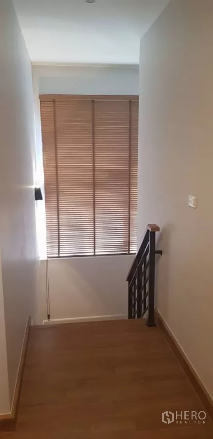 Detached House for rent in Bang Phli, Samut Prakan - Upper stair landing with wood flooring and tall window with blinds.