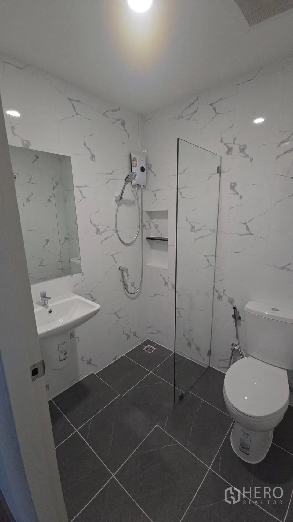 Townhouse for rent in Bang Phli, Samut Prakan - Bright bathroom with marble-effect tiles, glass shower, and wall-mounted water heater.