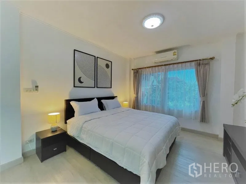 บ้าน ให้เช่าในSuan Luang, Bangkok - ห้องนอนหลักโปร่ง เตียงใหญ่ โต๊ะหัวเตียง เครื่องปรับอากาศ และหน้าต่างบานกว้าง.