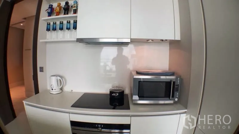 คอนโด ให้เช่าในKhlong Toei, Bangkok - ครัวสีขาวขนาดกะทัดรัด พร้อมเตา เครื่องดูดควัน ไมโครเวฟ และชั้นวาง