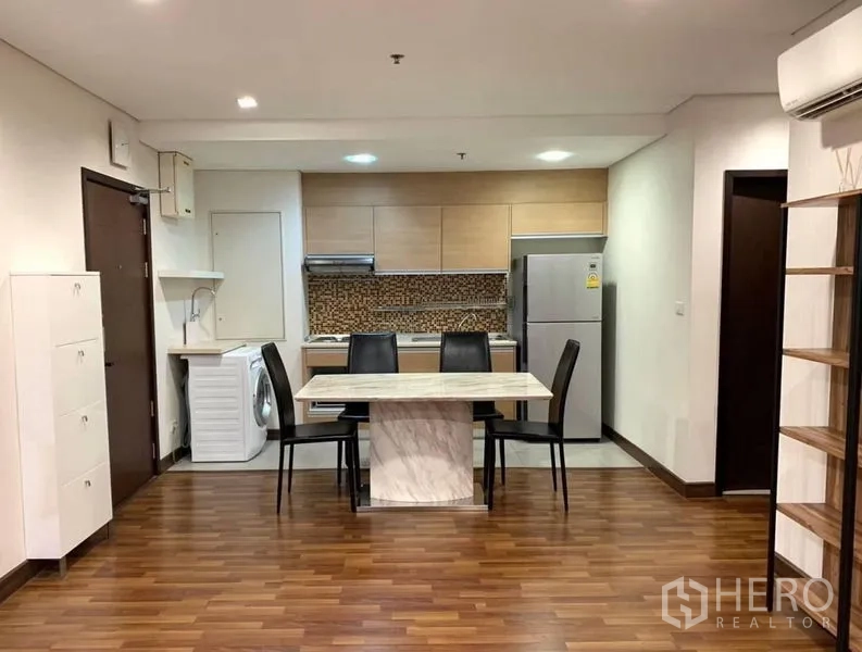 Condominium for rent in Watthana, Bangkok - Open-plan kitchen with mosaic backsplash, marble dining table and warm wood floors.