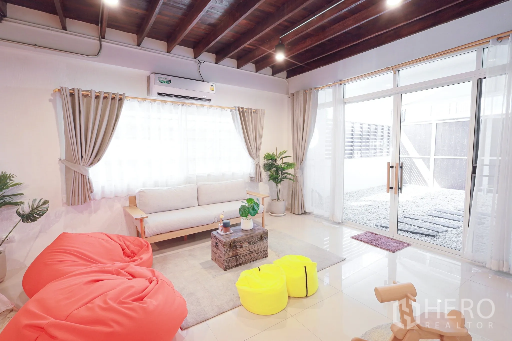 Townhouse for rent in Din Daeng, Bangkok - Cozy lounge with beanbags, coffee table and access to a private patio through glass doors.
