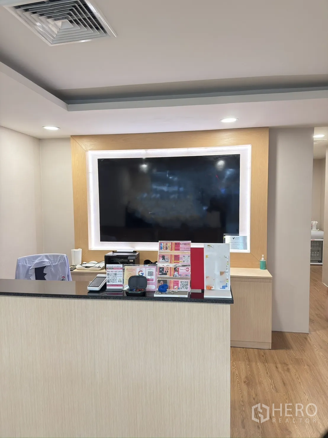 Retail Space for rent in Khlong Toei, Bangkok - Reception counter with a large display wall, wood flooring, and recessed lighting.