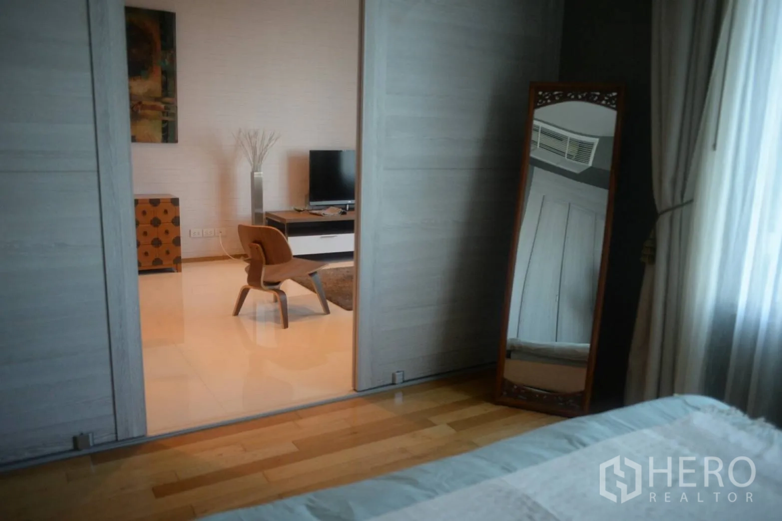 公寓 出租或出售在Khlong Toei, Bangkok - 从卧室透过推拉门望向客厅，可见电视与休闲椅。