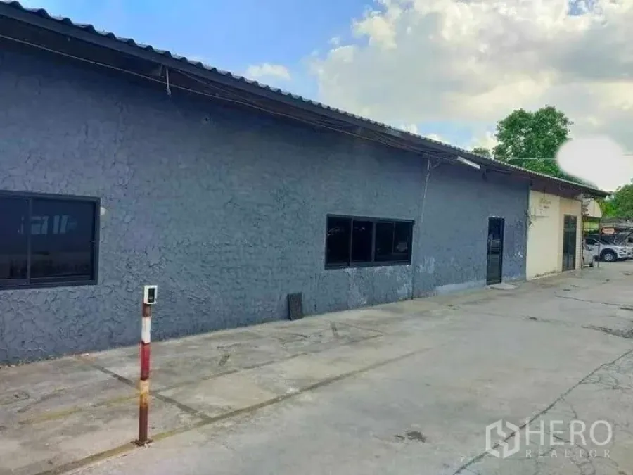 Warehouse for rent in Suan Luang, Bangkok - Long side elevation of the warehouse with windows and ample open apron for vehicle access.