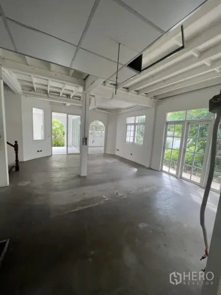 บ้าน ให้เช่าหรือขายในSathon, Bangkok - โถงชั้นล่างกว้าง พื้นคอนกรีต คานเปลือย ประตูกระจกบานใหญ่สู่สวน