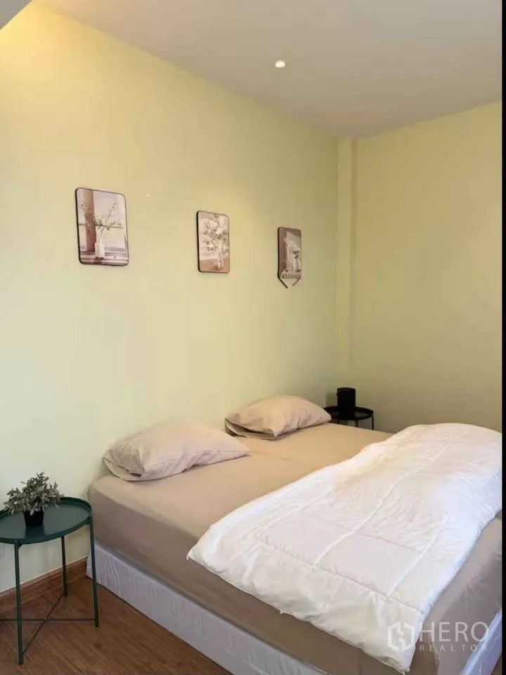 บ้าน ให้เช่าในKhlong Toei, Bangkok - ห้องนอนอบอุ่น เตียงควีน โต๊ะข้างทรงกลม และงานตกแต่งผนัง