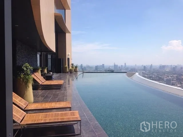 Condominium for rent in Khlong Toei, Bangkok - Rooftop infinity-edge pool with sun loungers overlooking Bangkok skyline.