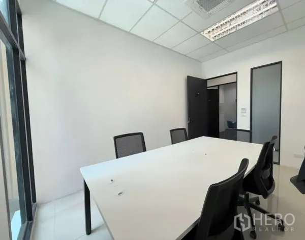办公空间 出租在Huai Khwang, Bangkok - 明亮的会议室，白色长桌、网面椅与嵌入式空调，旁有落地窗。