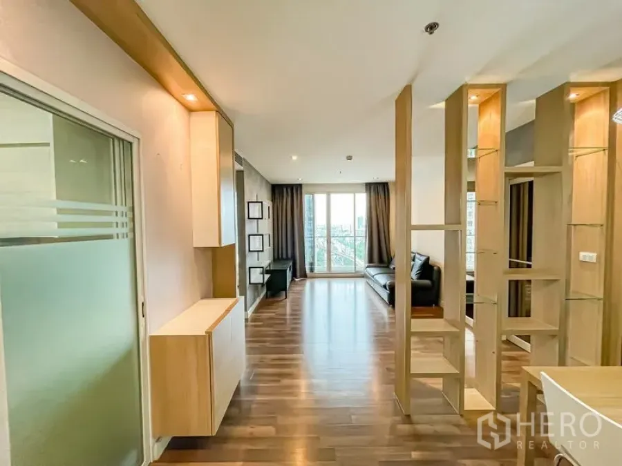 คอนโด ขาย - โถงทางเข้ามุ่งสู่ห้องนั่งเล่นสว่างจากระเบียง พร้อมฉากกั้นไม้