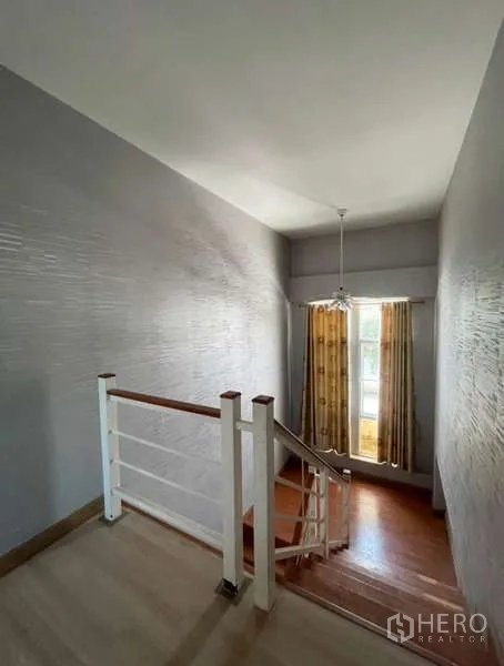 Detached House for rent in Bang Phli, Samut Prakan - Stairwell with white railing, tall window and pendant light.