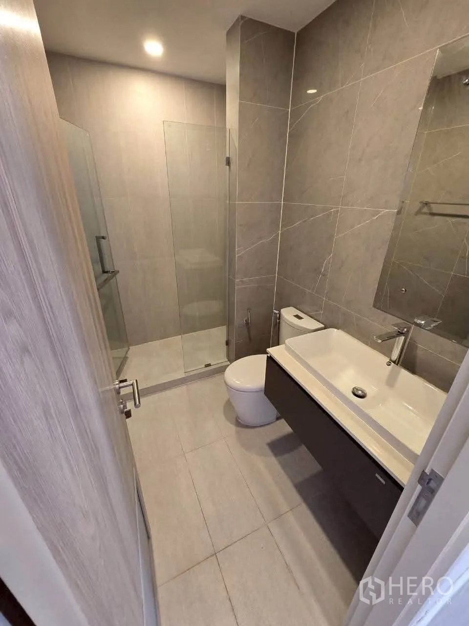 Detached House for rent or sale in Lat Krabang, Bangkok - Contemporary bathroom featuring glass shower enclosure and wide sink.