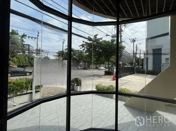 零售空间 出租在Phra Khanong, Bangkok - 从店内通过弧形玻璃望向街景与车行道