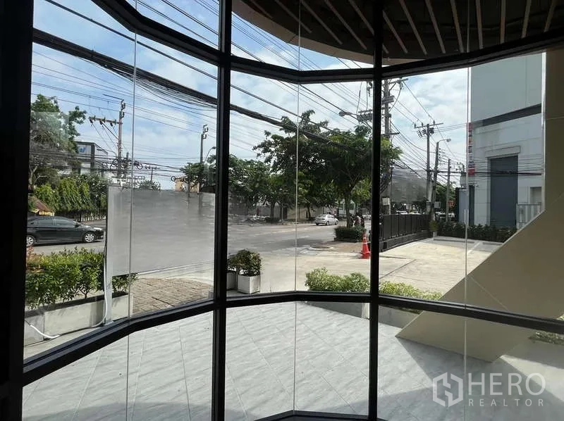 零售空间 出租在Phra Khanong, Bangkok - 从店内通过弧形玻璃望向街景与车行道