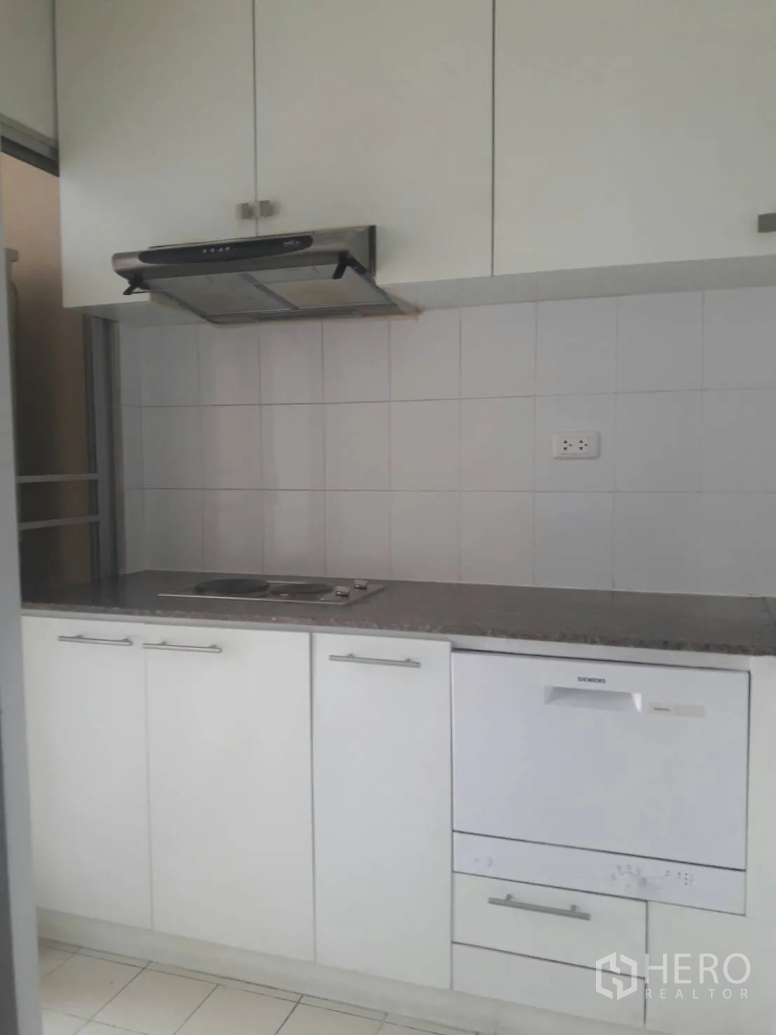 คอนโด ให้เช่าในKhlong Toei, Bangkok - ครัวปิดแยกเป็นสัดส่วน ตู้สีขาว เตาและเครื่องดูดควัน ผนังกระเบื้อง และเครื่องล้างจานบิวท์อิน