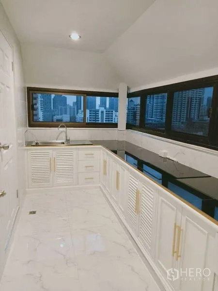 Condominium for  in Watthana, Bangkok - Separate kitchen with long countertops, white cabinets and skyline views.