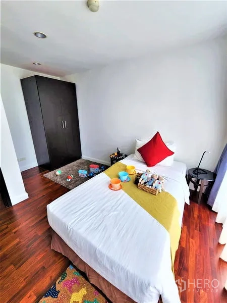 公寓 出租在Bang Rak, Bangkok - 温馨卧室，单人床、深色衣柜与木地板。