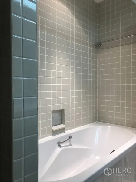 公寓 出租在Pathum Wan, Bangkok - 浴室配白色浸泡浴缸与浅灰色方砖墙面。