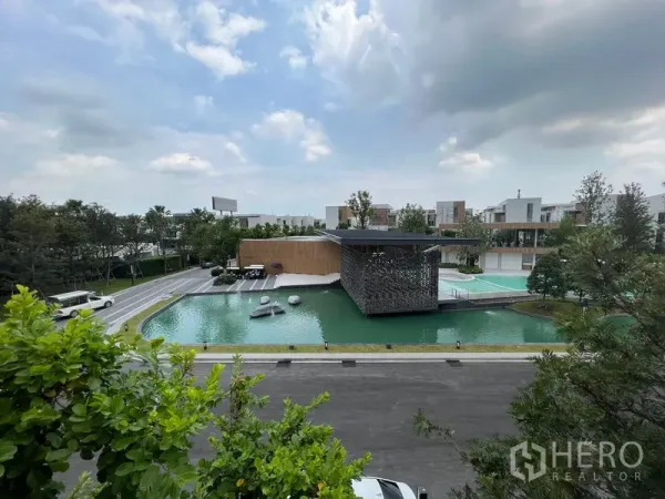 Detached House for rent or sale in Saphan Sung, Bangkok - Community clubhouse beside a landscaped pond with walkways and greenery.