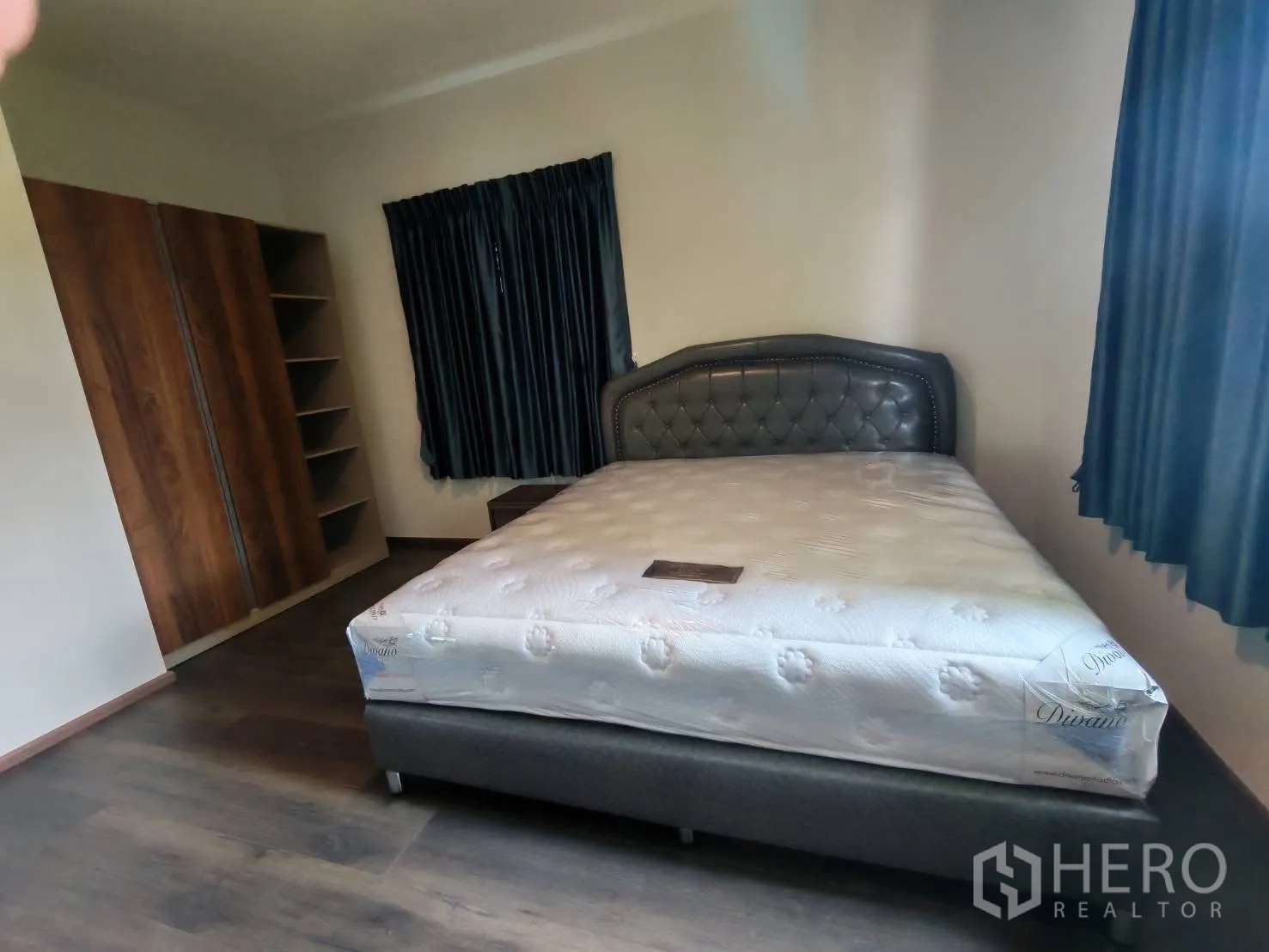 บ้านเดี่ยว for rent in Bang Phli, Samut Prakan - ห้องนอนพร้อมเตียงสีเทา ตู้เสื้อผ้า และหน้าต่างติดผ้าม่านสีเข้ม