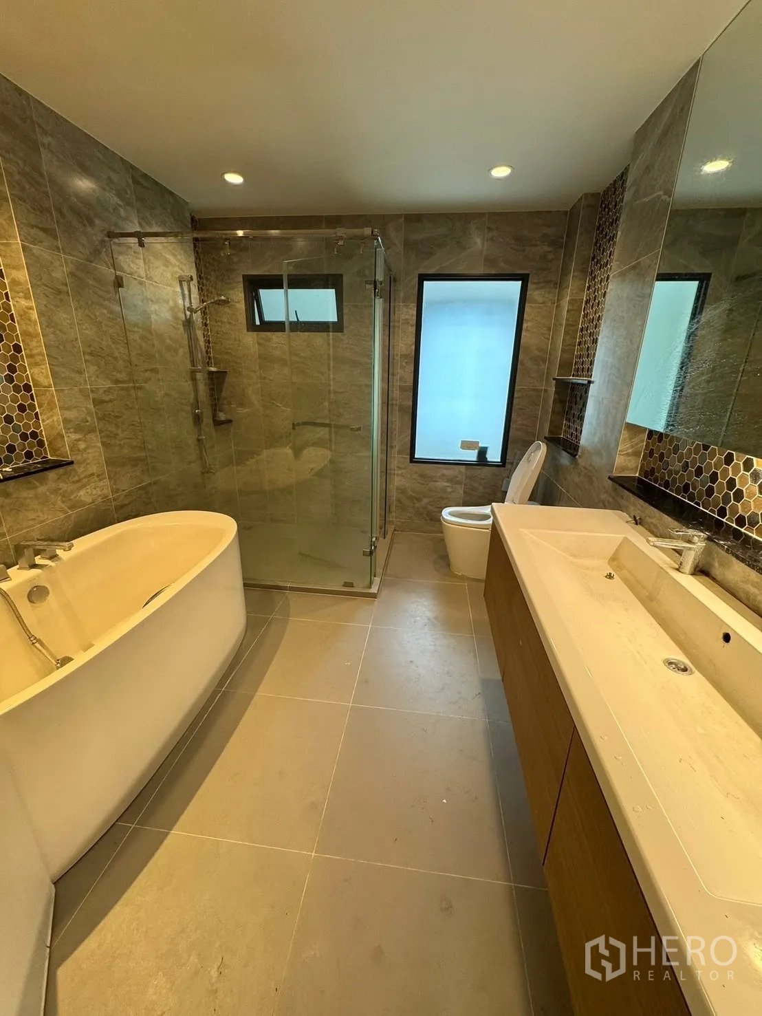 独立式住宅 出售在Mueang Pathum Thani, Pathum Thani - 主卫配浴缸、玻璃淋浴与双台盆。