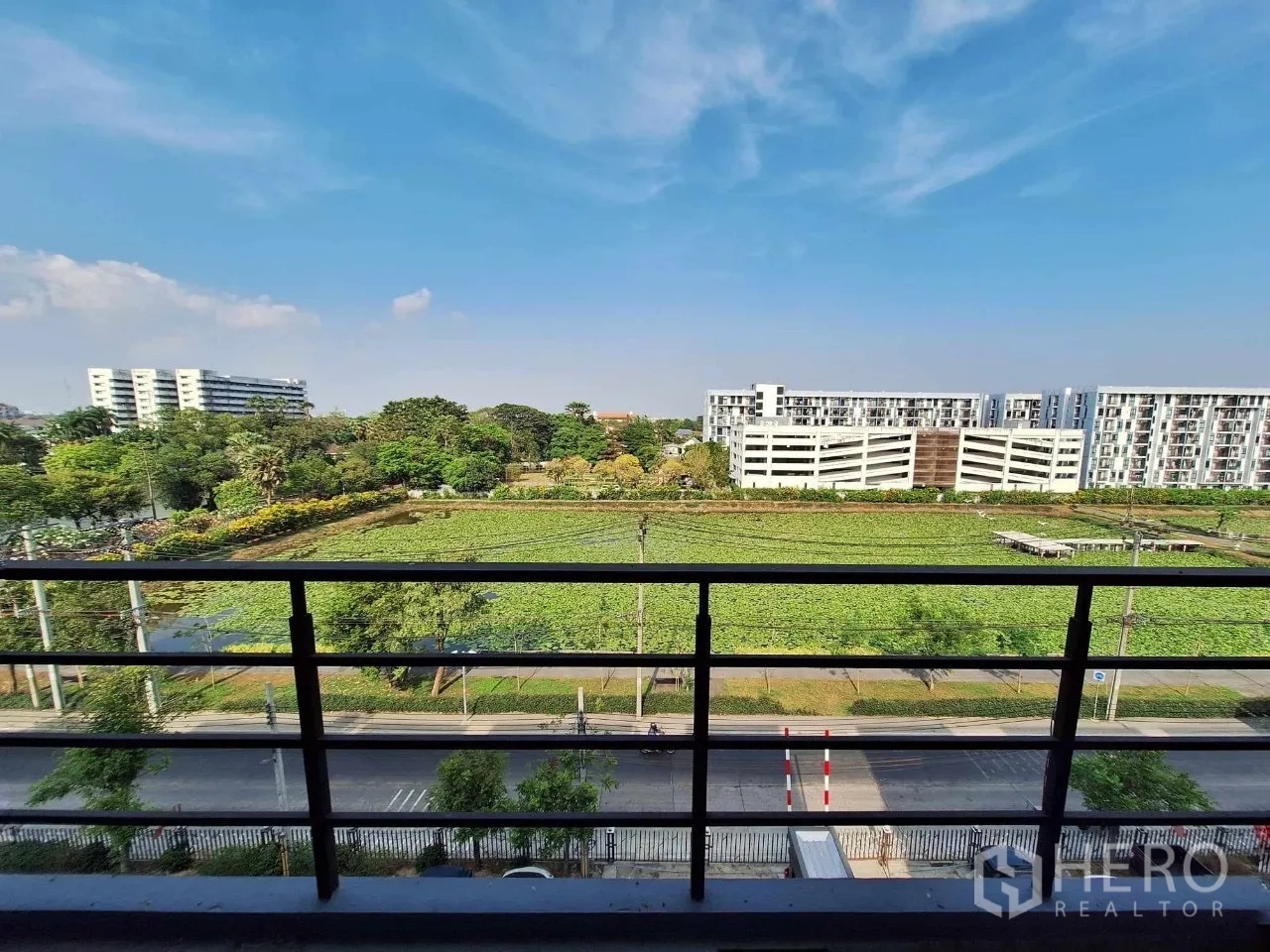 Home Office for sale in Bueng Kum, Bangkok - Balcony view over a green field and nearby low-rise residences in Bueng Kum.