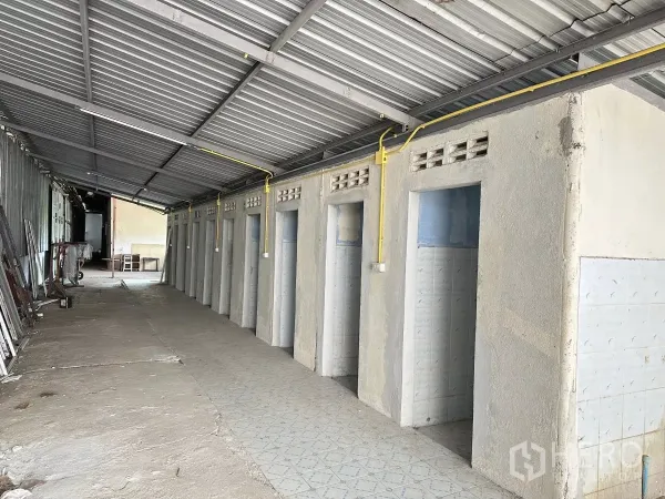 Warehouse for sale in Nong Chok, Bangkok - Row of tiled restroom and shower cubicles under a metal canopy in the service zone.
