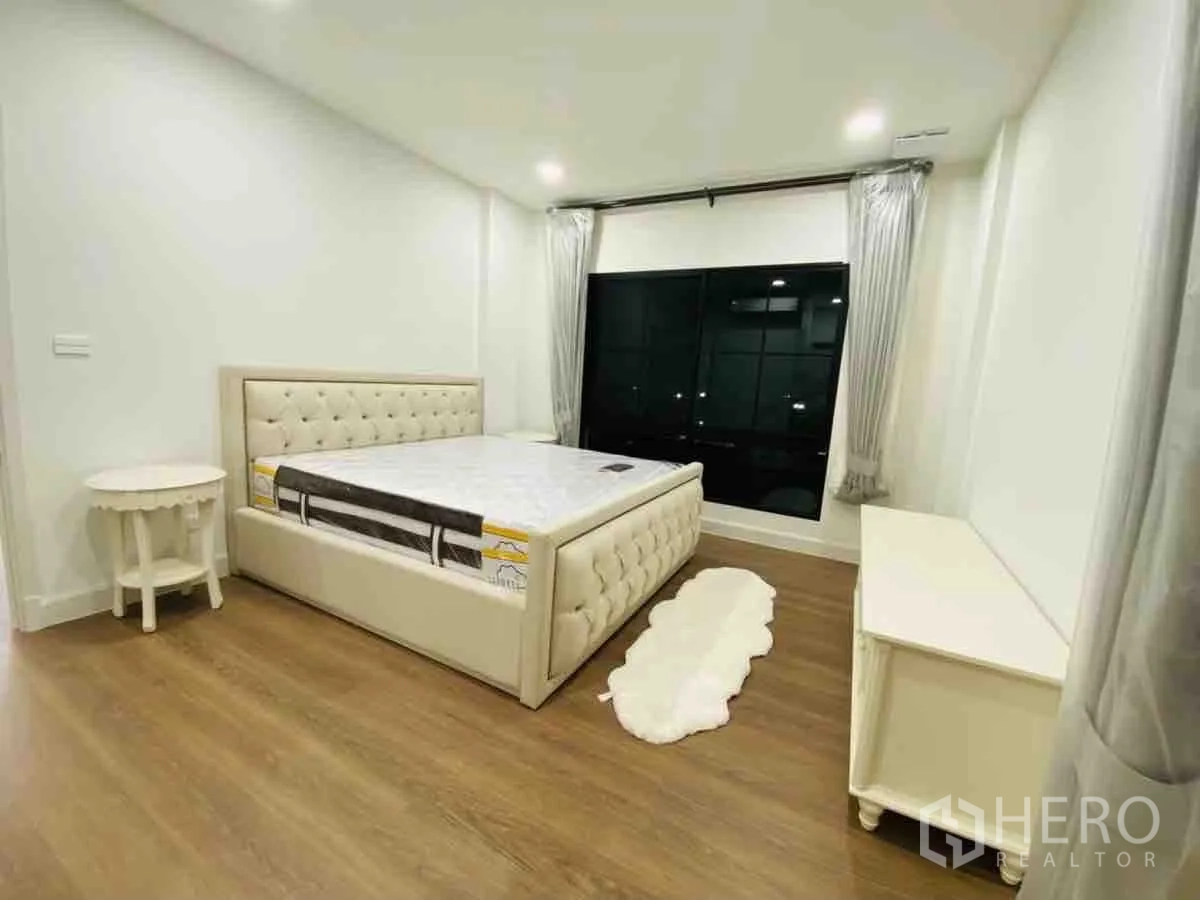 Detached House for rent or sale in Saphan Sung, Bangkok - Bedroom with tufted bed, large picture window and wood flooring