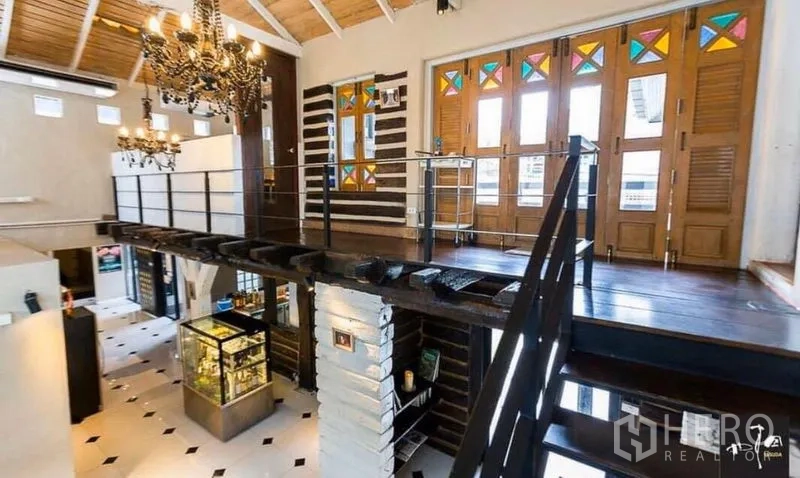 พื้นที่ขายปลีก ให้เช่าในKhlong Toei, Bangkok - ชั้นลอยพื้นไม้พร้อมโคมระย้าและประตูบานเฟี้ยมกระจกสี