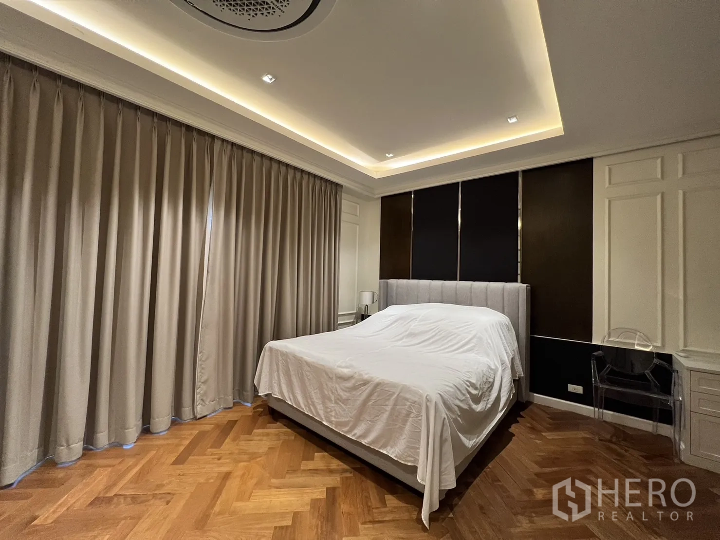 Detached House for rent in Suan Luang, Bangkok - Bedroom with upholstered bed, dark feature wall and curtains.