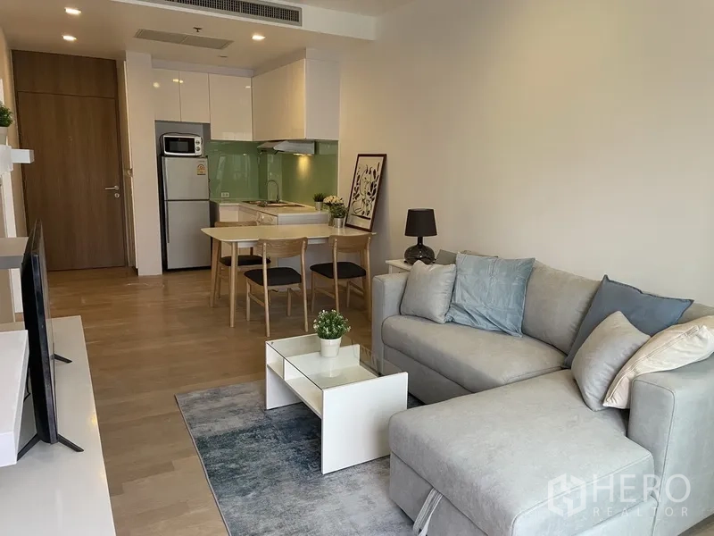 公寓 出租在Bangkok - 开放式起居区，配餐桌与小巧厨房，色调柔和。