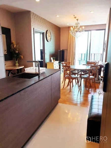 公寓 出租或出售在Khlong Toei, Bangkok - 开放式餐厨区，水晶吊灯与中岛设计，采光充足并通向阳台。