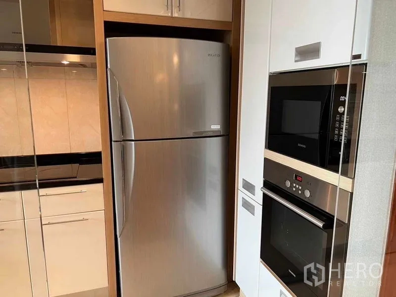 公寓 出租或出售在Watthana, Bangkok - 不锈钢双门冰箱与叠放的内置烤箱、微波炉特写