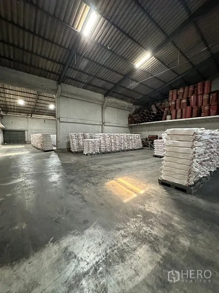 Warehouse for rent in Lat Krabang, Bangkok - Open storage hall with polished concrete floor and bright fluorescent lighting in an industrial warehouse.
