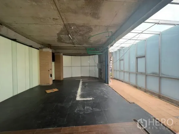 零售空间 出租在Watthana, Bangkok - 毛坯零售室内，混凝土天花、深色地砖与磨砂玻璃墙。