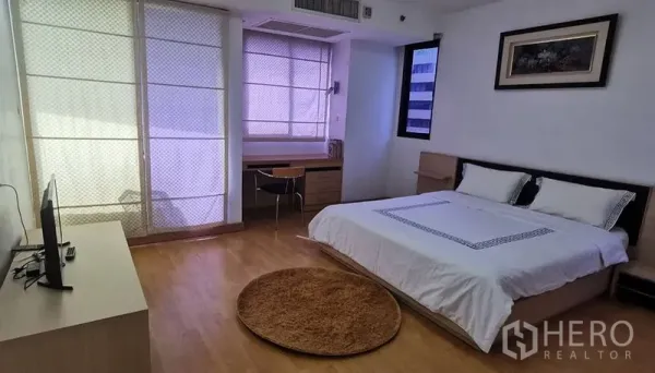 Condominium for rent in Watthana, Bangkok - Spacious master bedroom with king bed, TV stand, desk, and large windows.