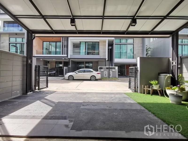 ทาวน์เฮาส์ ขาย - ที่จอดรถมีหลังคาพร้อมสวนข้างบ้าน มองเห็นแนวทาวน์โฮมสมัยใหม่
