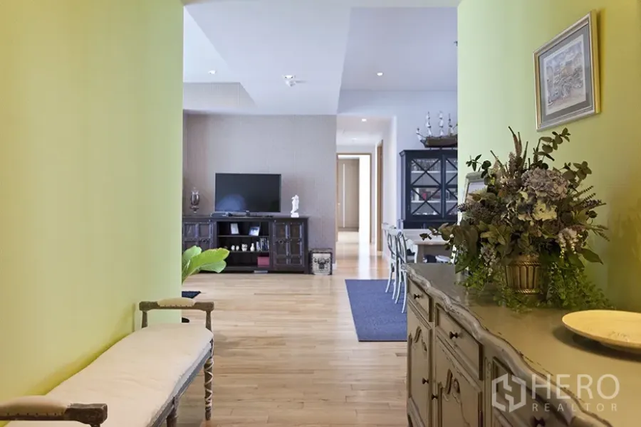 คอนโด ให้เช่าในKhlong Toei, Bangkok - ห้องนั่งเล่นและรับประทานอาหารสว่าง พื้นไม้ ผนังสีเขียว พร้อมตู้ทีวี