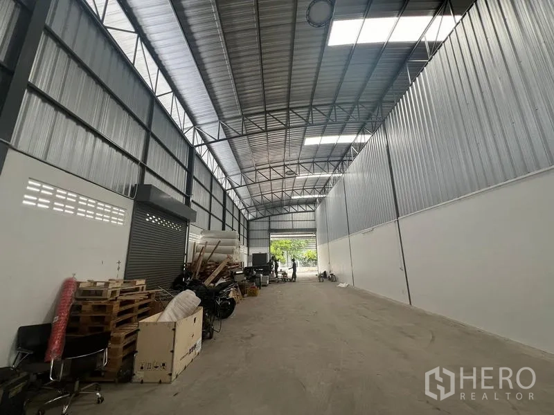 货栈 出租在Khlong Sam Wa, Bangkok - 仓库长通道朝向入口，金属夹芯墙体，天窗与通风砖提供良好采光通风。