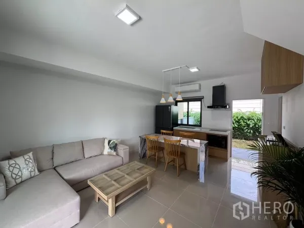 ทาวน์เฮาส์ ให้เช่าในBang Phli, Samut Prakan - ห้องนั่งเล่นสว่างด้วยโคมแขวน มีประตูเลื่อนเชื่อมสวนหลังบ้าน